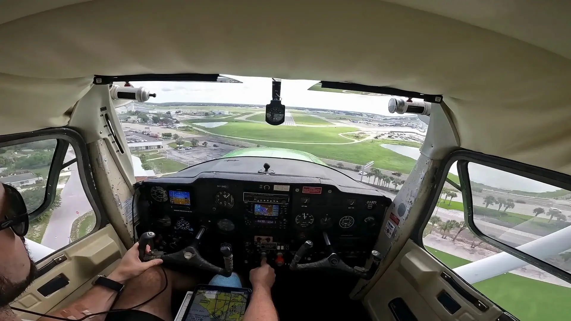 Airplane landing on runway seen from pilot over the shoulder view