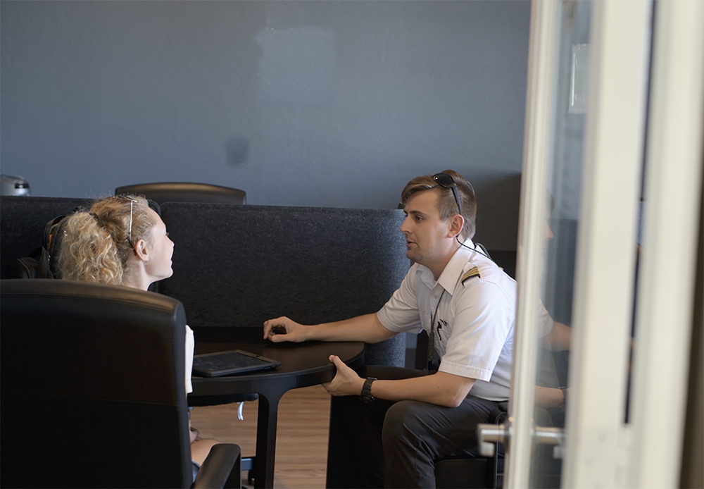Flight instructor talking with a student across a table