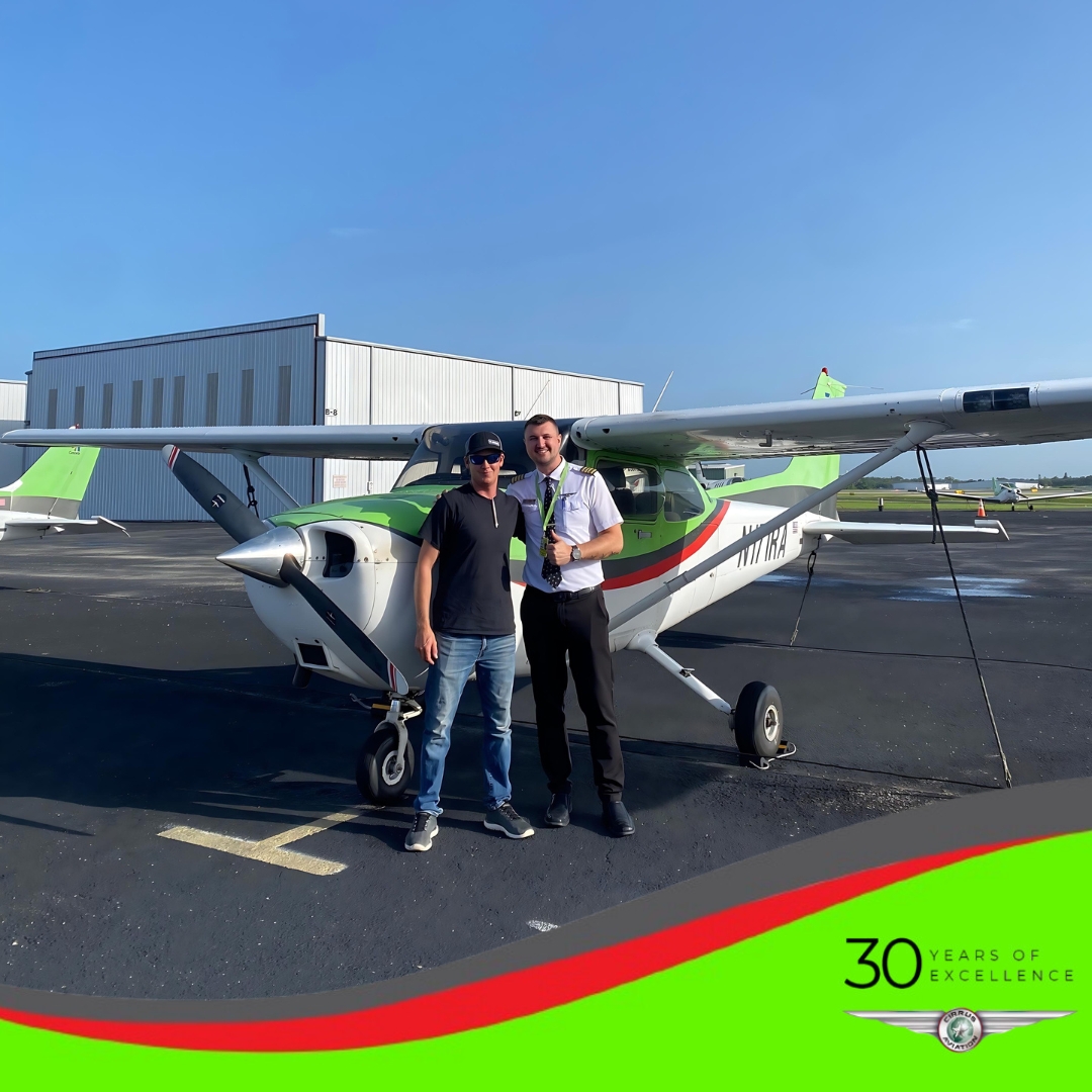 Student and CFI standing in front of a Cessna aircraft, Cirrus Aviation watermark at the bottom of the image