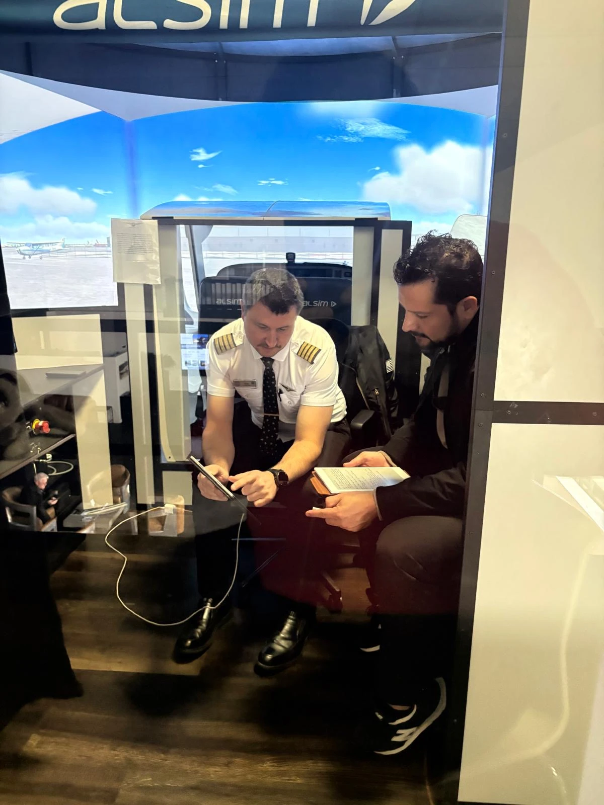 Cirrus Aviation instructor briefing a student inside an Alsim flight simulator