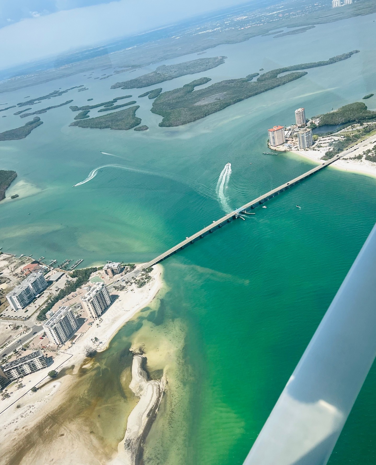 Gulf Coast islands, a bridge, and turquoise water seen from a Cirrus Aviation training aircraft